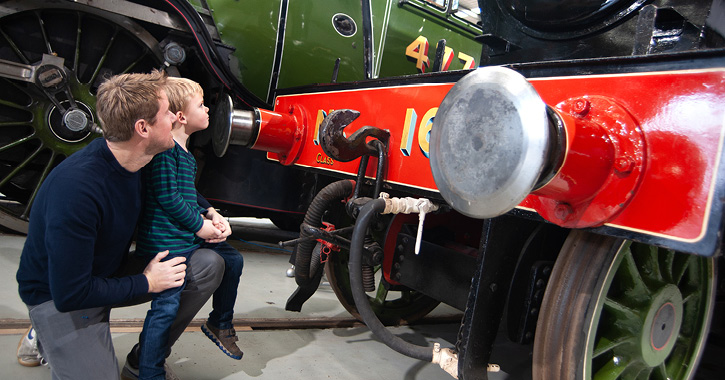 Dad and son looking at a train inside Locomotion